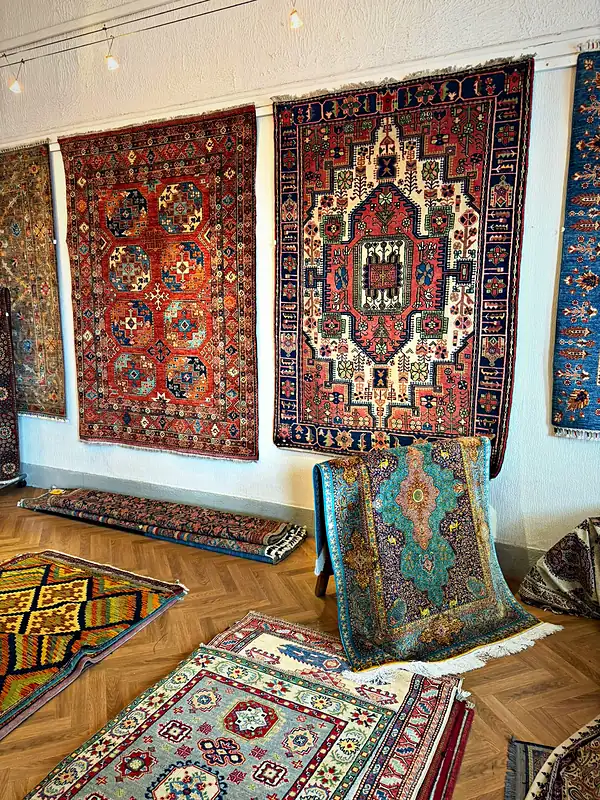 Mur de la boutique tapissé de tapis noués à la main.